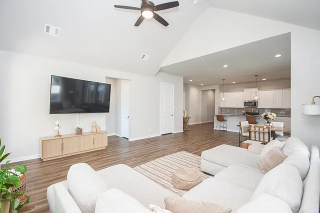 a kitchen with stainless steel appliances kitchen island granite countertop a dining table chairs and white cabinets