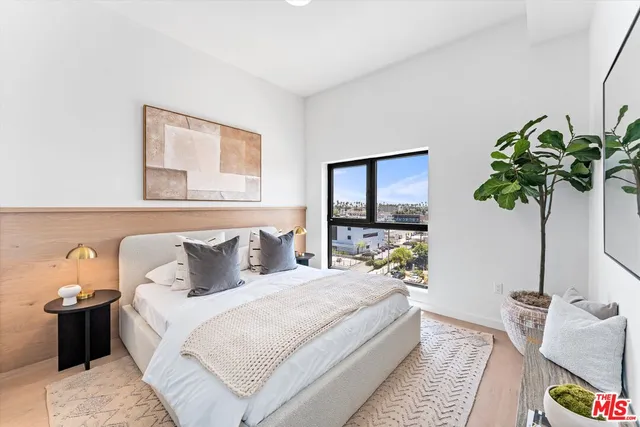 a bedroom with bed and a potted plant