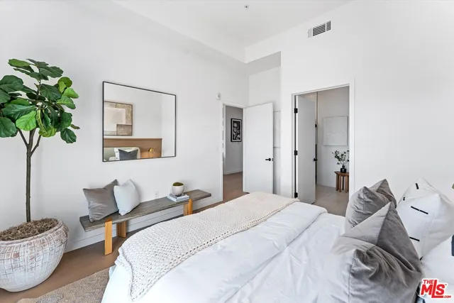 a bedroom with bed and a potted plant