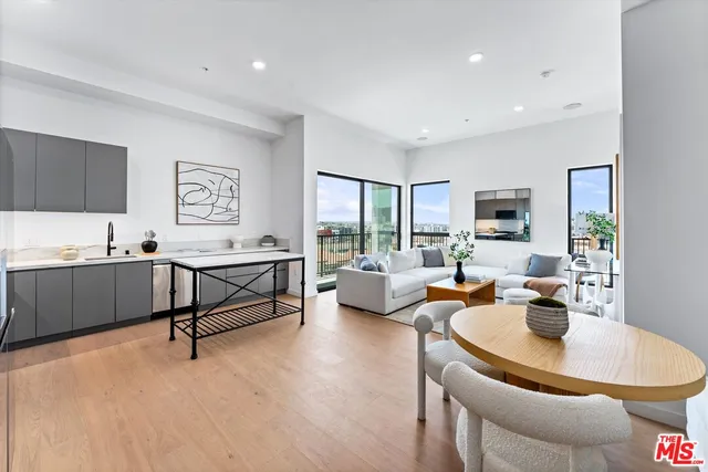 a living room with furniture kitchen view and a window