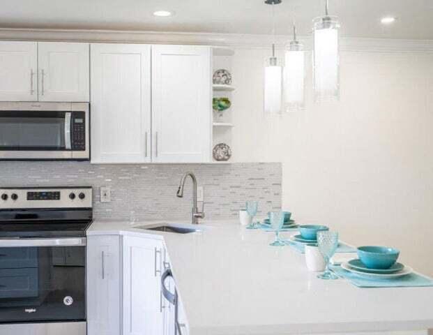 9284 Vista Del Lago, Unit 34F Boca Raton, FL 33428 - Photo 3 of 15 a kitchen with stainless steel appliances granite countertop a sink stove and microwave