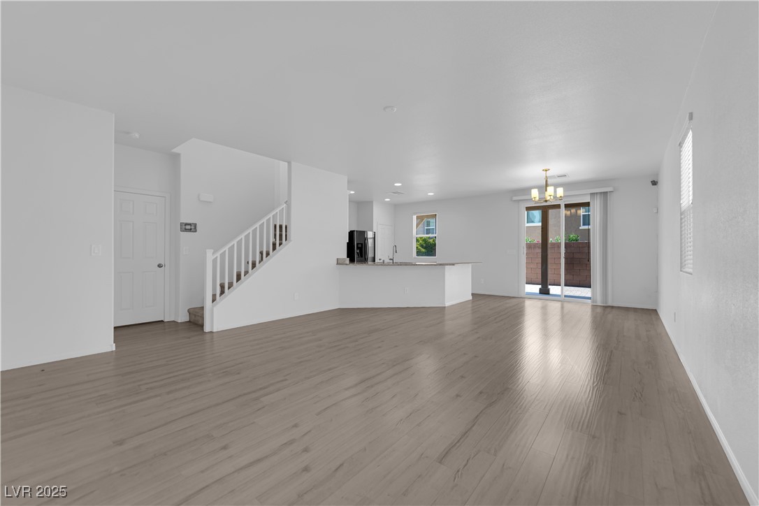 9205 Keystone Ridge Avenue Las Vegas, NV 89148 - Photo 4 of 40 Unfurnished living room featuring a chandelier, st
