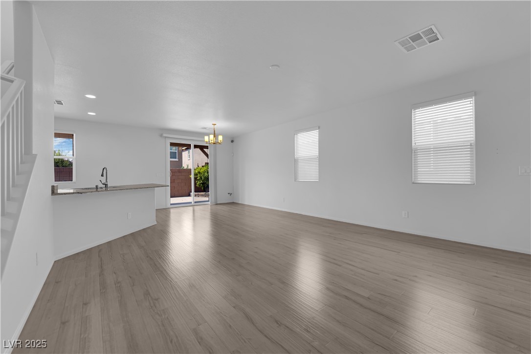 9205 Keystone Ridge Avenue Las Vegas, NV 89148 - Photo 5 of 40 Unfurnished living room with a chandelier, stairwa