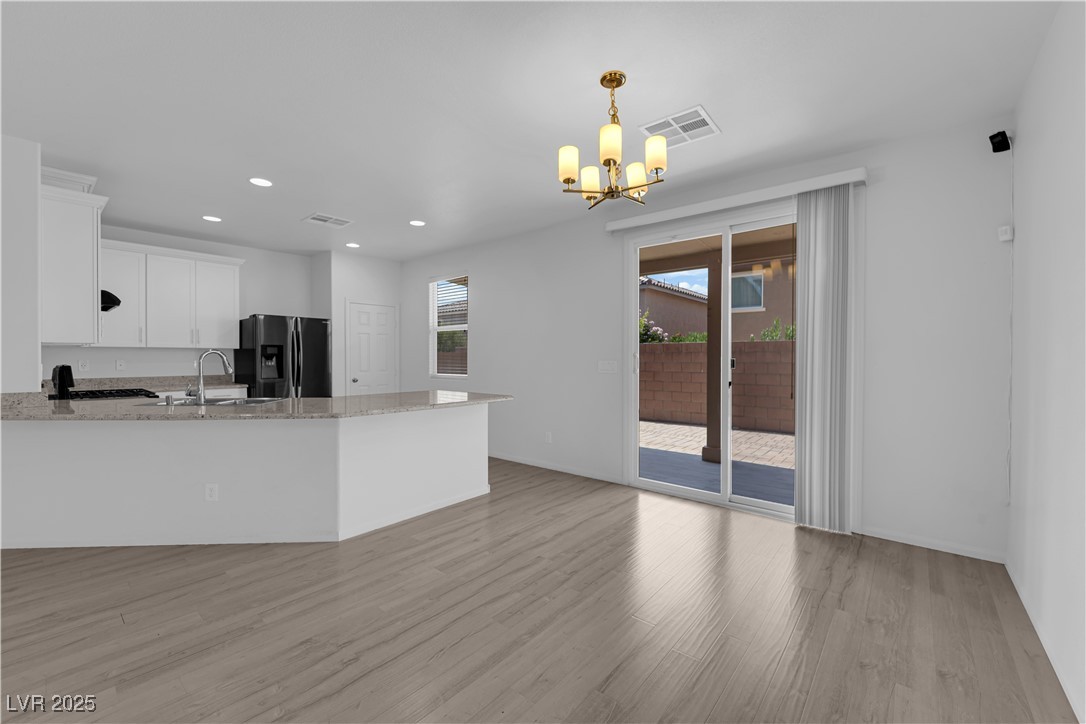 9205 Keystone Ridge Avenue Las Vegas, NV 89148 - Photo 7 of 40 Kitchen featuring a chandelier, light wood-type fl