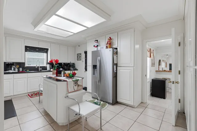 a kitchen with refrigerator and white cabinets