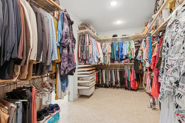 a view of walk in closet with clothes