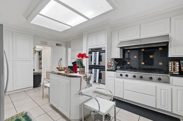 a kitchen with white cabinets and appliances