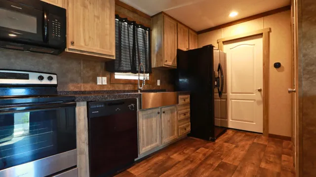 a kitchen with stainless steel appliances granite countertop a refrigerator and a stove