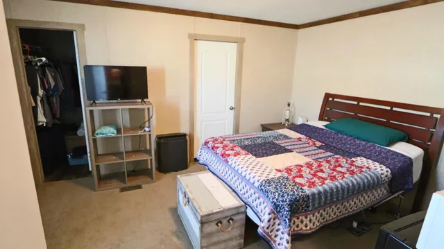 a bedroom with a bed and a television