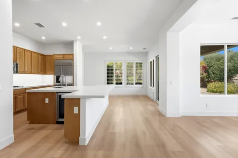 a kitchen with stainless steel appliances granite countertop white cabinets granite counter tops and a window