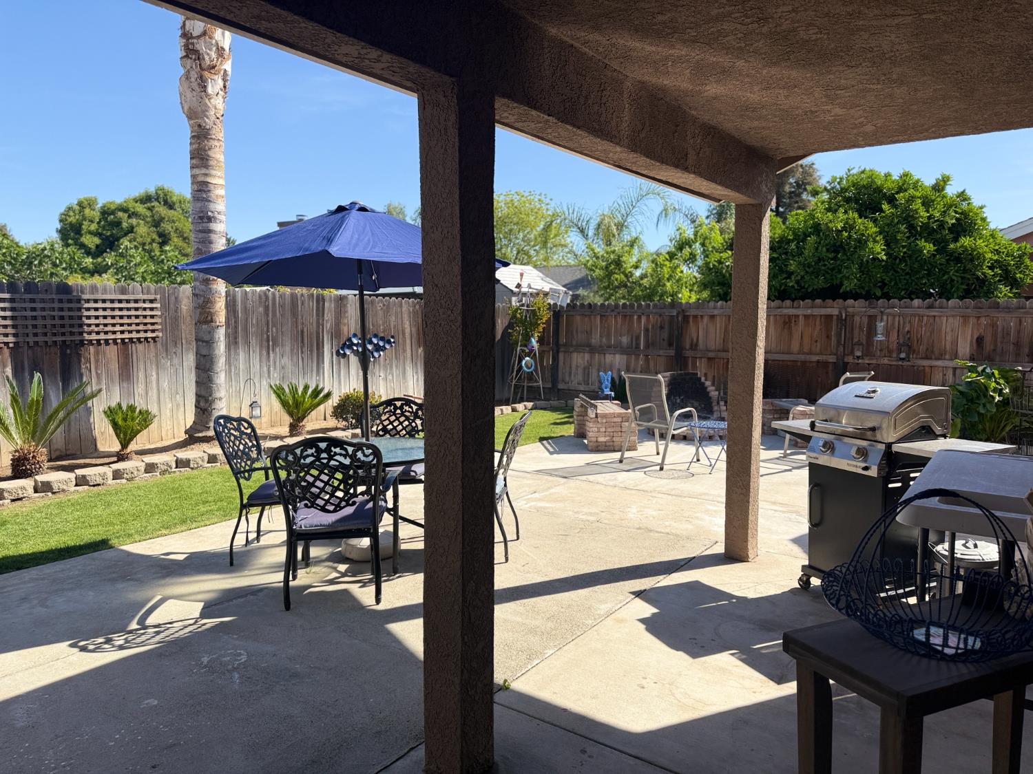 14312 West B Street Kerman, CA 93630 - Photo 16 of 24 a view of a patio with a table chairs and a yard