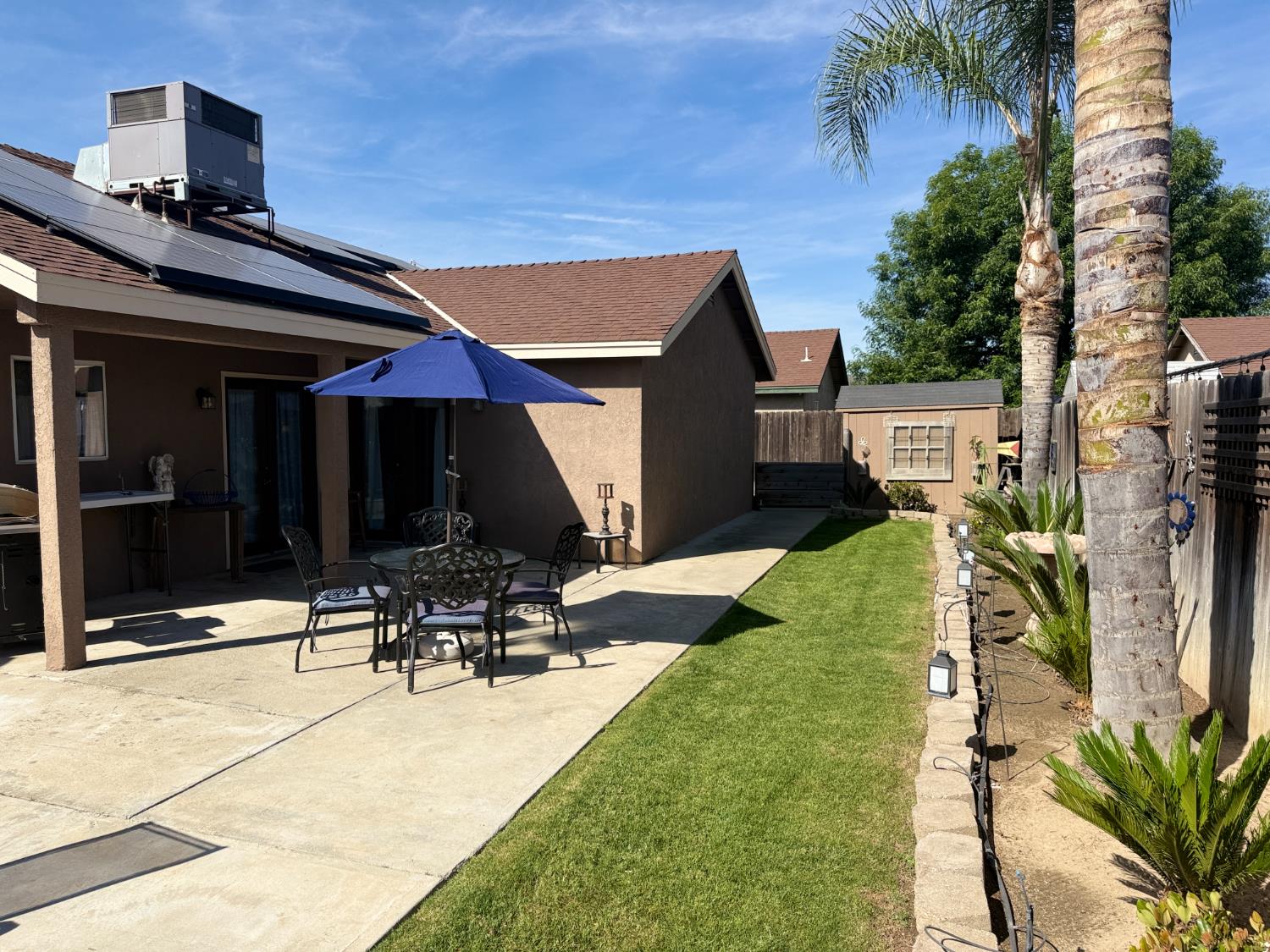 14312 West B Street Kerman, CA 93630 - Photo 17 of 24 a view of a chair and tables in the patio in front of the house