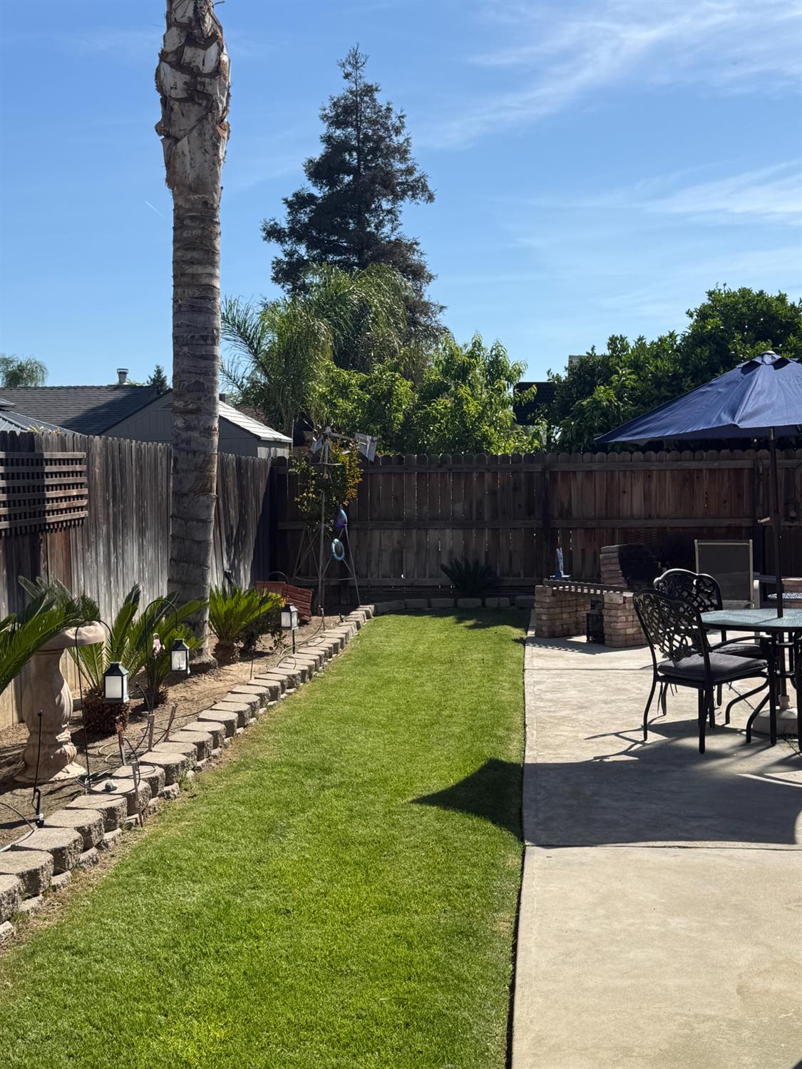 14312 West B Street Kerman, CA 93630 - Photo 22 of 24 a view of a backyard with a bench and potted plants