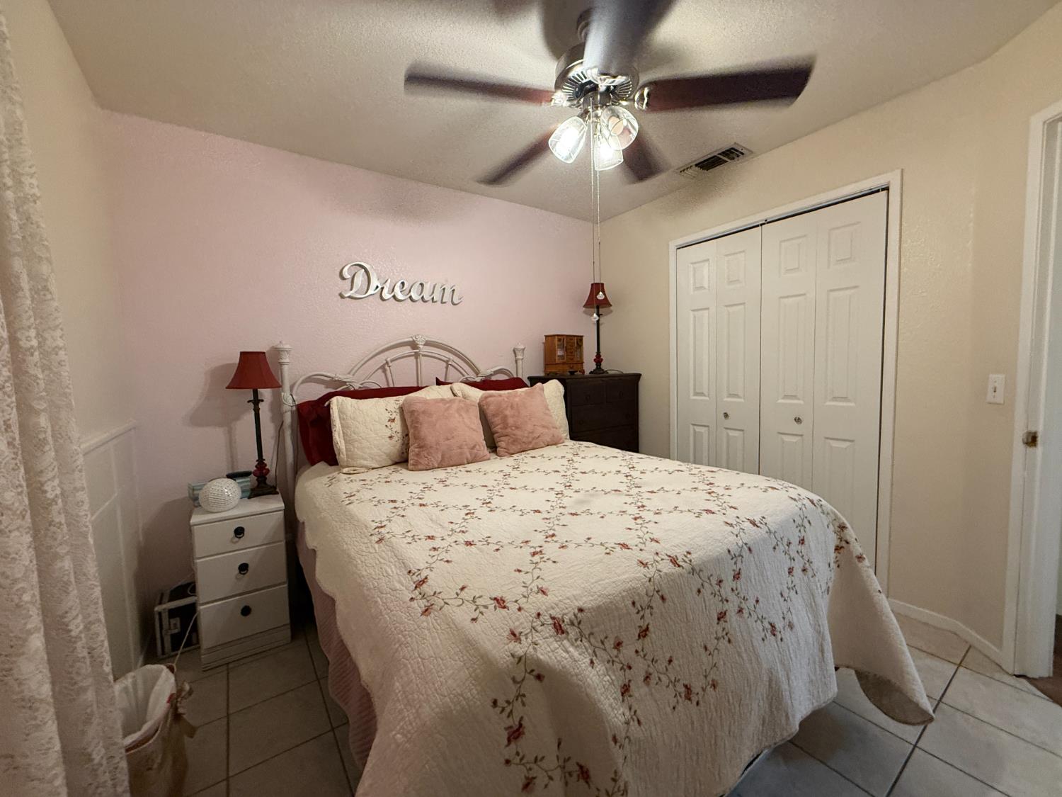 14312 West B Street Kerman, CA 93630 - Photo 10 of 24 a bedroom with a bed and a chandelier