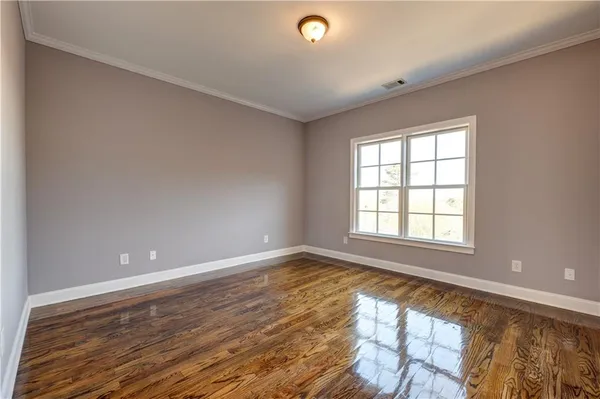 a view of an empty room with window and cabinet