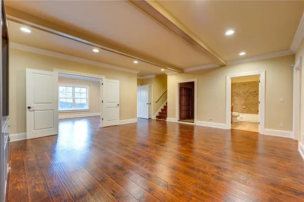 a view of an empty room with wooden floor