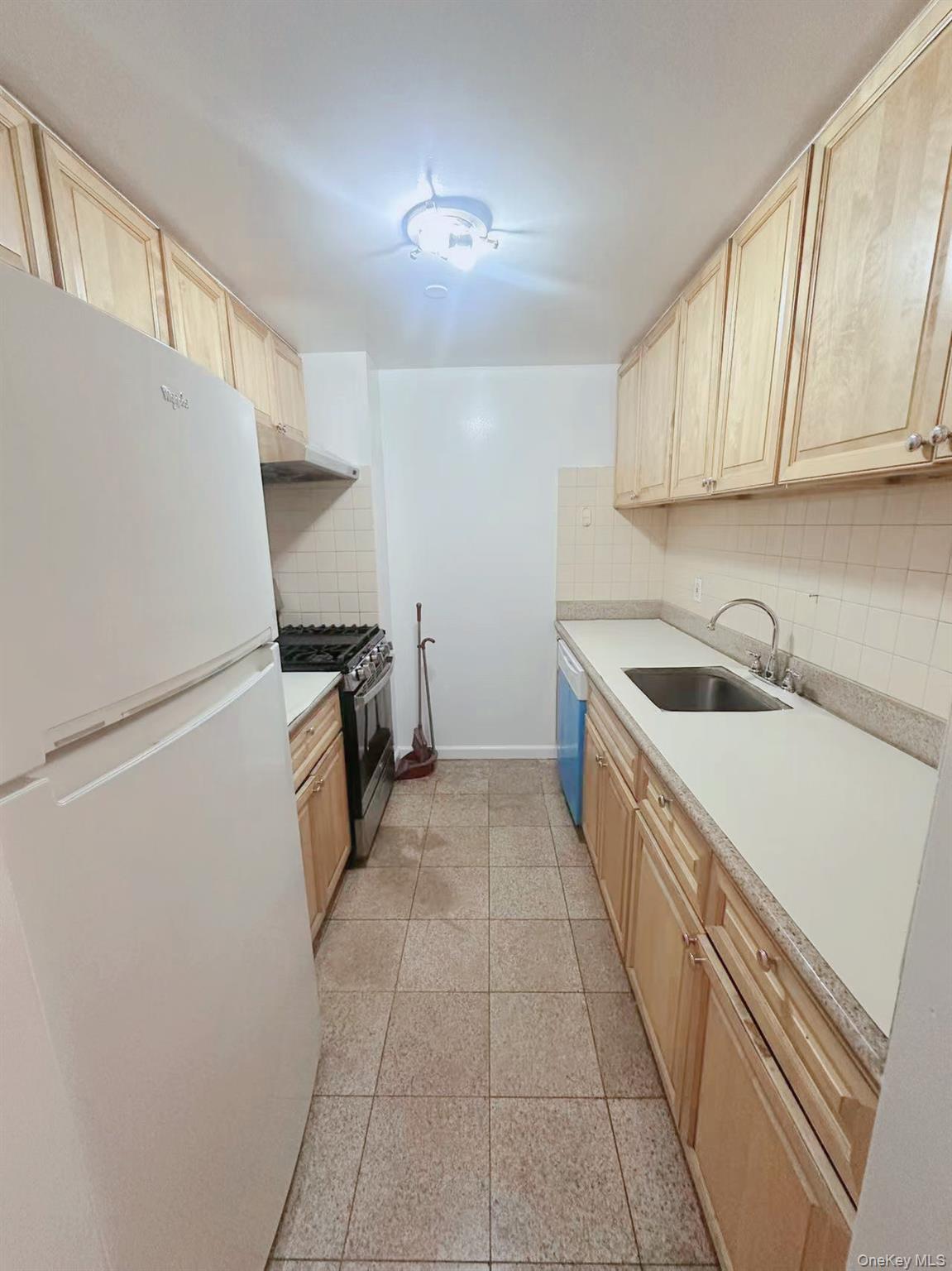 136-16 35th Avenue, Unit 2B Queens, NY 11354 - Photo 3 of 8 a kitchen with refrigerator and cabinets