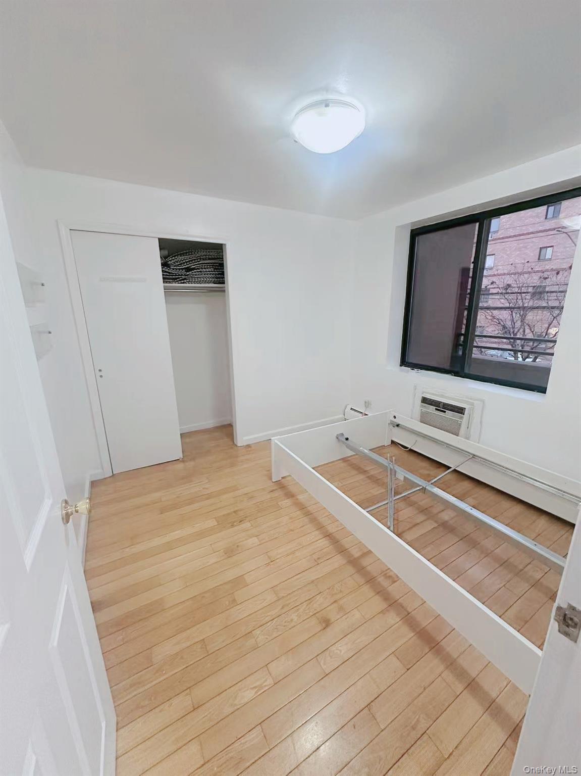 136-16 35th Avenue, Unit 2B Queens, NY 11354 - Photo 5 of 8 a bedroom with a bed and a flat screen tv