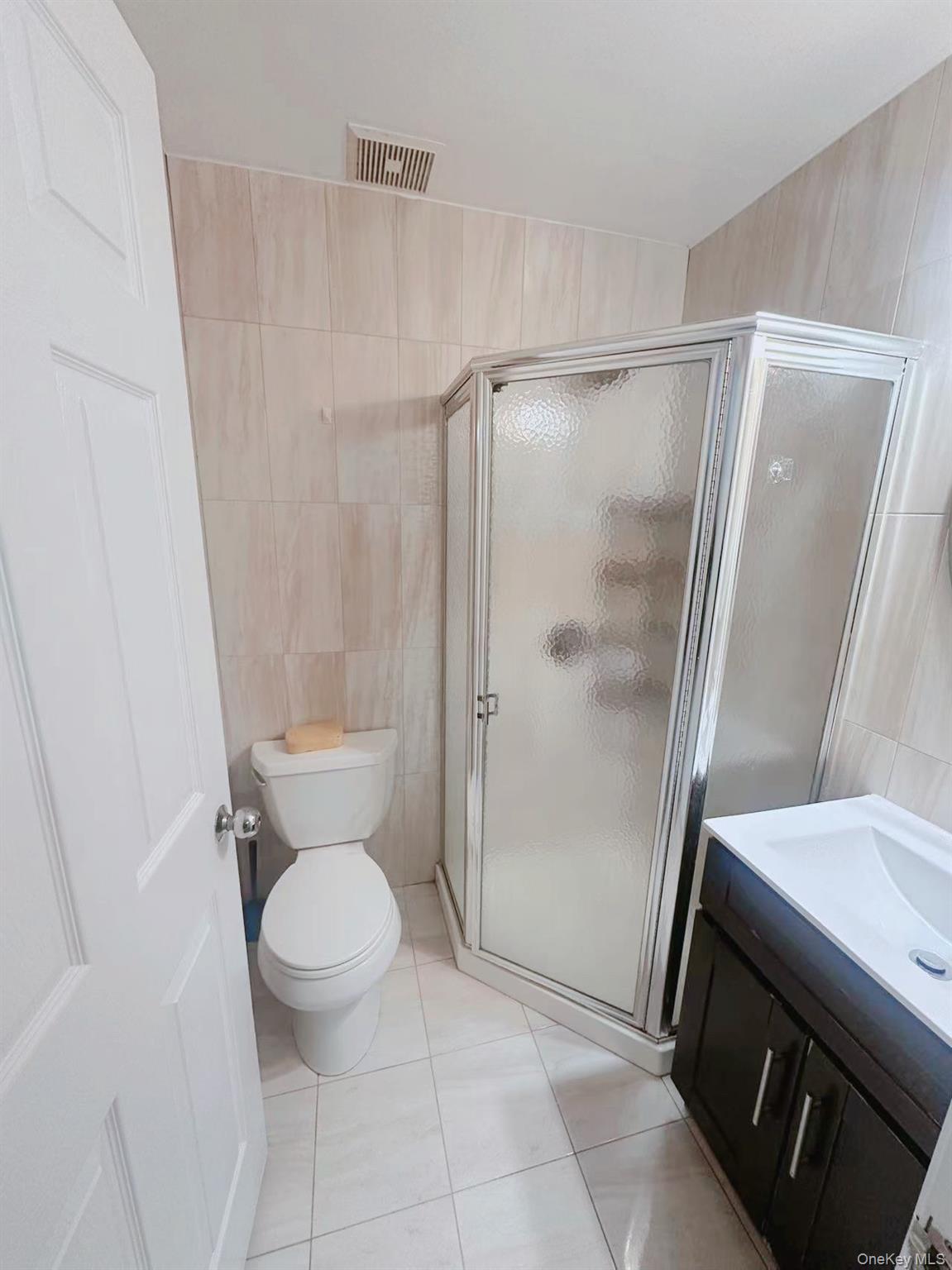 136-16 35th Avenue, Unit 2B Queens, NY 11354 - Photo 6 of 8 a bathroom with a granite countertop shower and a toilet