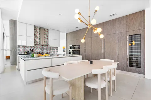 a kitchen with a dining table chairs and white cabinets