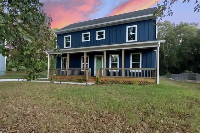 a view of a brick house with a large windows and a large tree