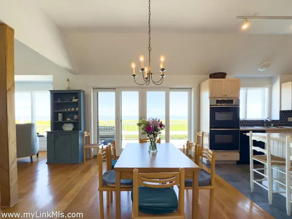 a view of a dining room with furniture a chandelier and wooden floor