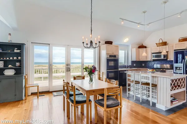 a kitchen with kitchen island granite countertop a sink counter space appliances and a view of living room