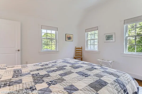 a bedroom with two beds and a chair