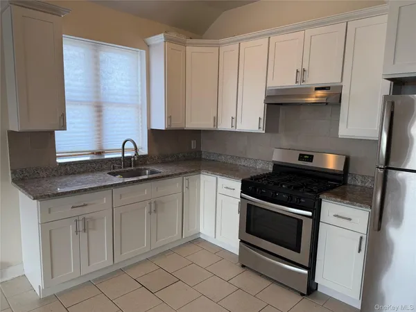 a kitchen with granite countertop white cabinets and white appliances
