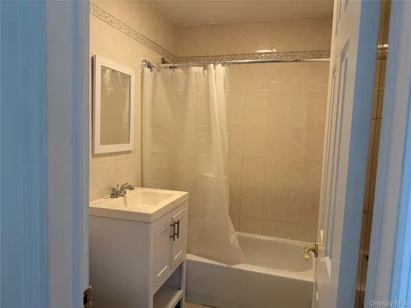 a bathroom with a sink a mirror a bathtub and shower