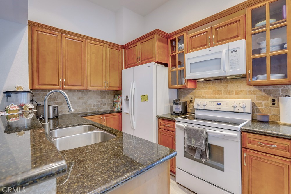 87 Grenada Street, Unit 174 Laguna Niguel, CA 92677 - Photo 4 of 17 a kitchen with stainless steel appliances granite countertop a sink stove and refrigerator