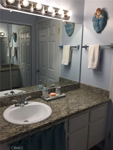 a bathroom with a granite countertop sink and a mirror