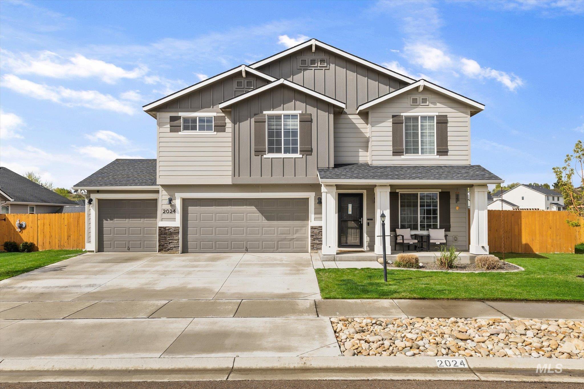 View of front of home featuring covered porch, driveway, roof with shingles, and a garage