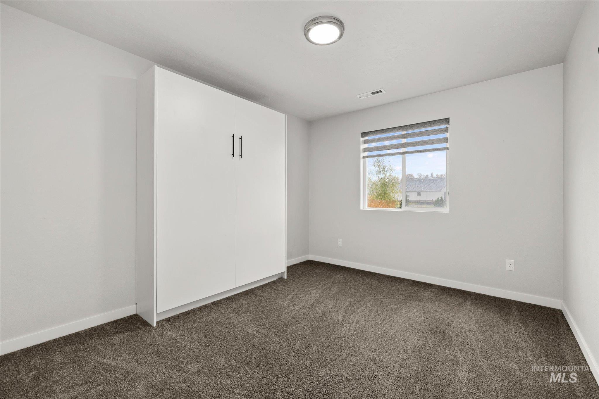2024 Placerville Street Middleton, ID 83644 - Photo 12 of 38 Unfurnished room with dark carpet and baseboards