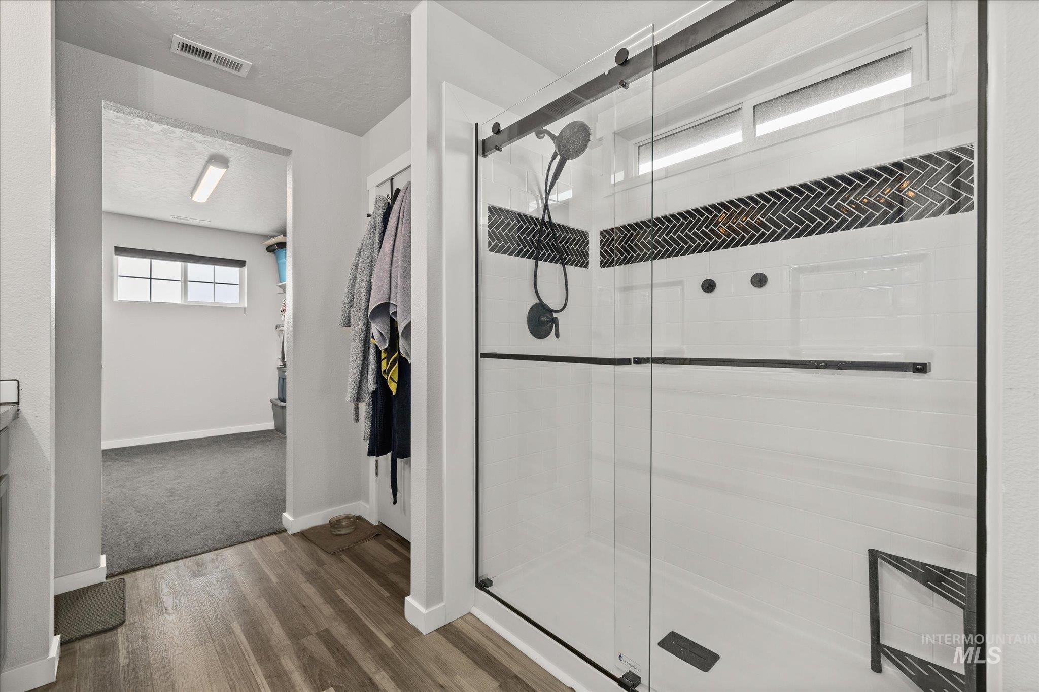 2024 Placerville Street Middleton, ID 83644 - Photo 21 of 38 Bathroom with a stall shower, dark wood finished floors, and a textured ceiling