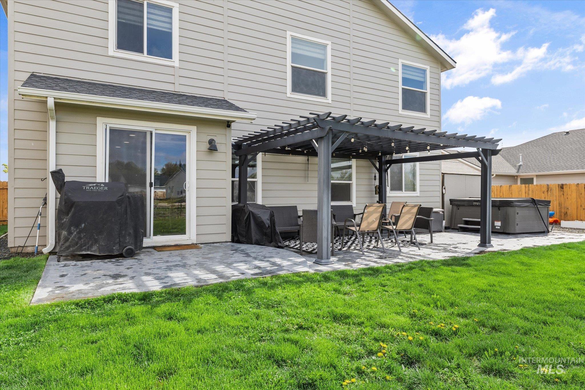 2024 Placerville Street Middleton, ID 83644 - Photo 32 of 38 Back of house with a hot tub, a pergola, and a patio