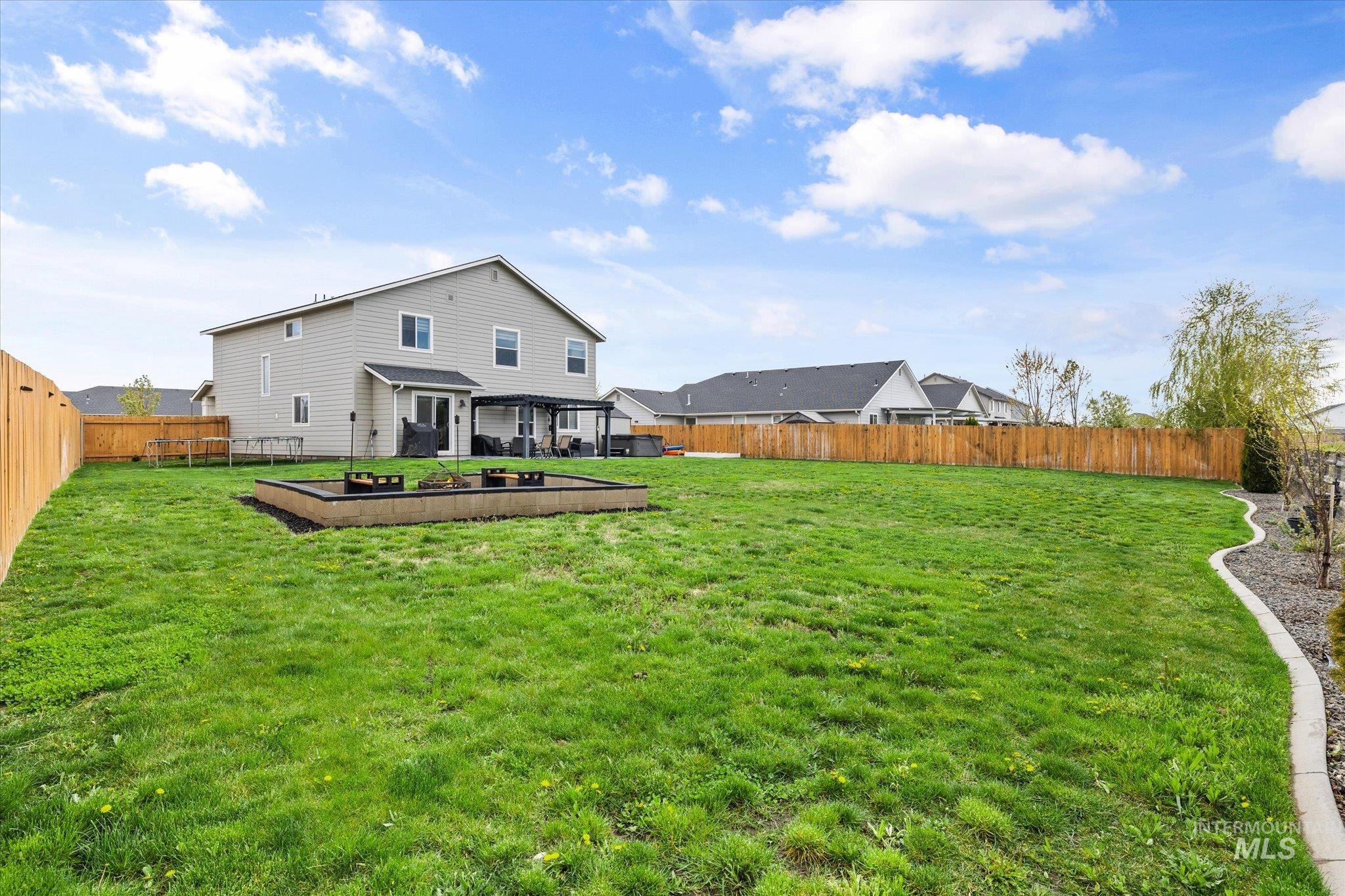 2024 Placerville Street Middleton, ID 83644 - Photo 35 of 38 Rear view of house with a fenced backyard, a patio, and a vegetable garden