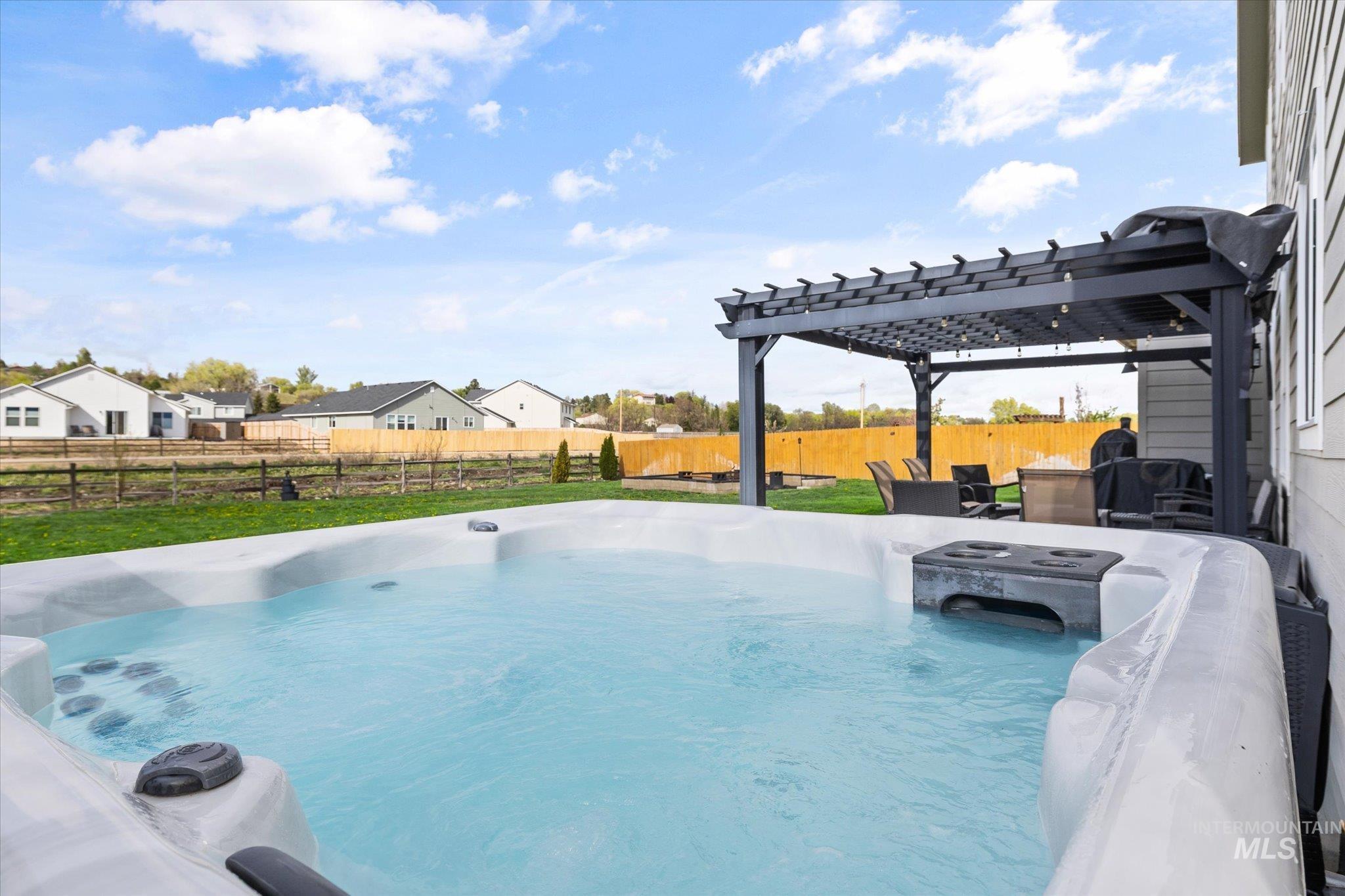 2024 Placerville Street Middleton, ID 83644 - Photo 37 of 38 View of swimming pool with a pergola, a hot tub, a pool, a fenced backyard, and a residential view