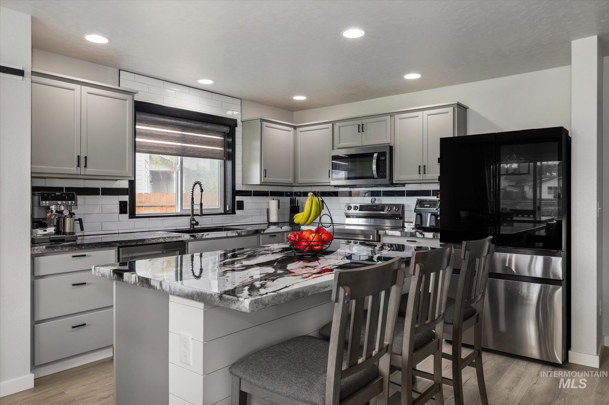 2024 Placerville Street Middleton, ID 83644 - Photo 4 of 38 Kitchen with gray cabinetry, stainless steel appliances, a kitchen island, light wood-style flooring, and recessed lighting