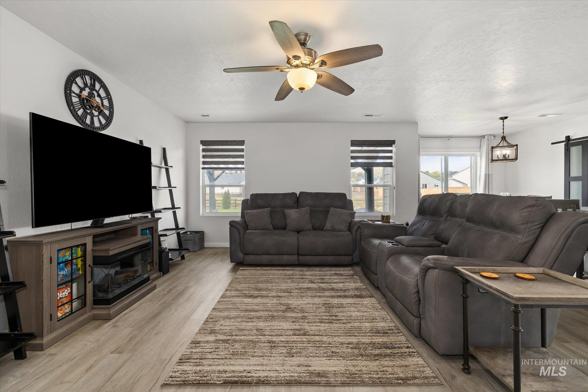 2024 Placerville Street Middleton, ID 83644 - Photo 8 of 38 Living room with light wood-type flooring, ceiling fan, and a barn door
