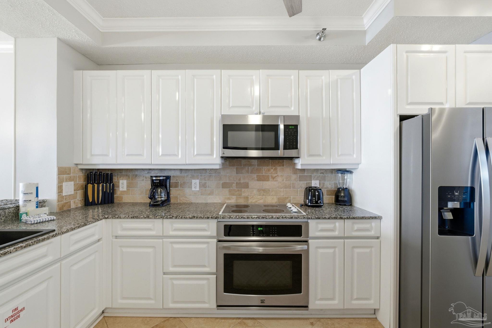 13601 Perdido Key Drive, Unit W2C Perdido Key, FL 32507 - Photo 19 of 63 a kitchen with stainless steel appliances granite countertop white cabinets a refrigerator a sink and a stove