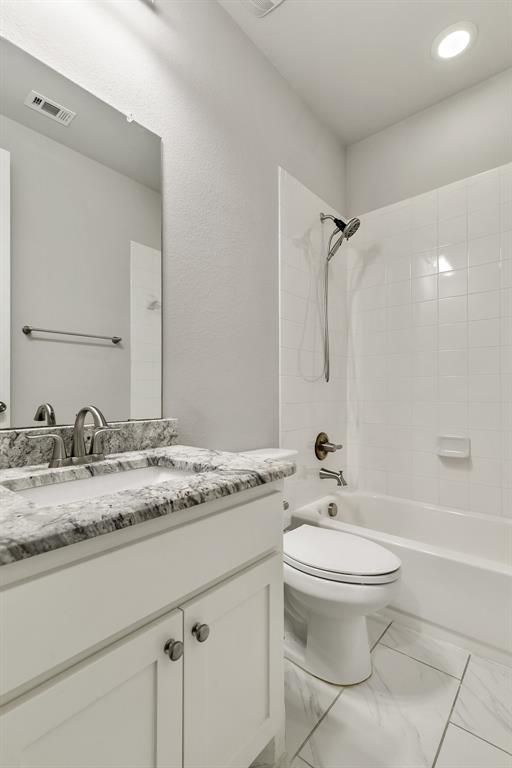 2936 Prescott The Colony, TX 75056 - Photo 23 of 28 a bathroom with a granite countertop sink toilet a mirror and a bathtub
