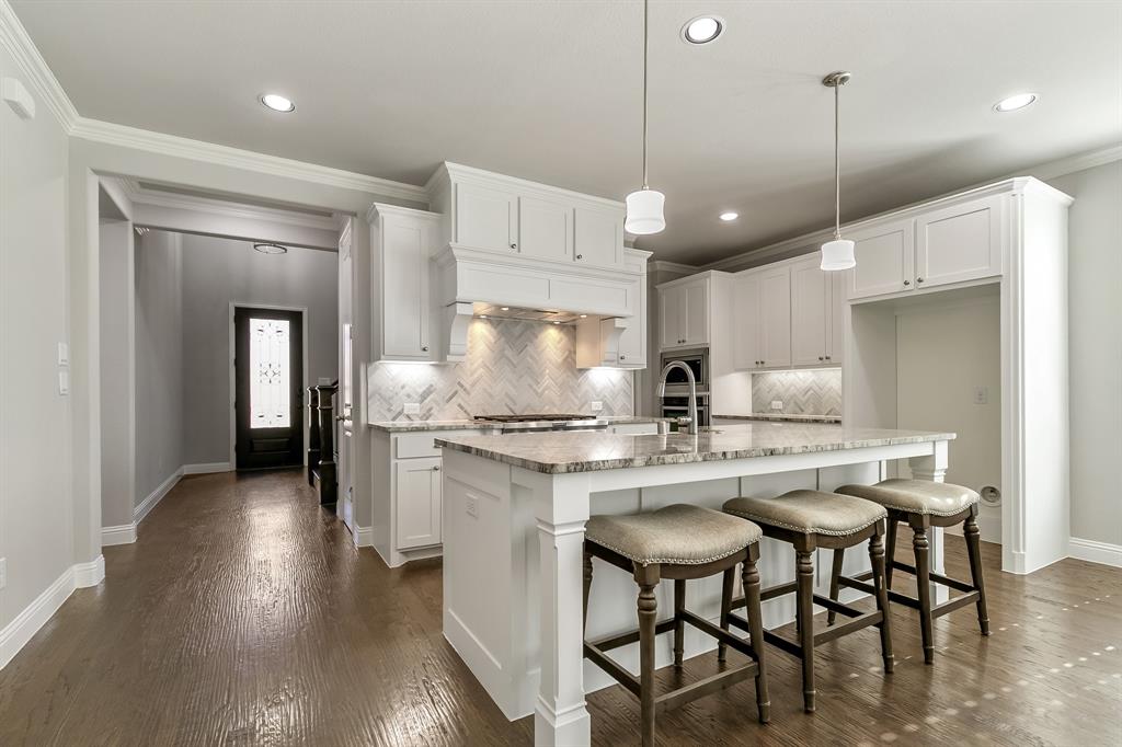 2936 Prescott The Colony, TX 75056 - Photo 10 of 28 a kitchen with stainless steel appliances granite countertop a stove a sink a refrigerator and a dining table with wooden floor
