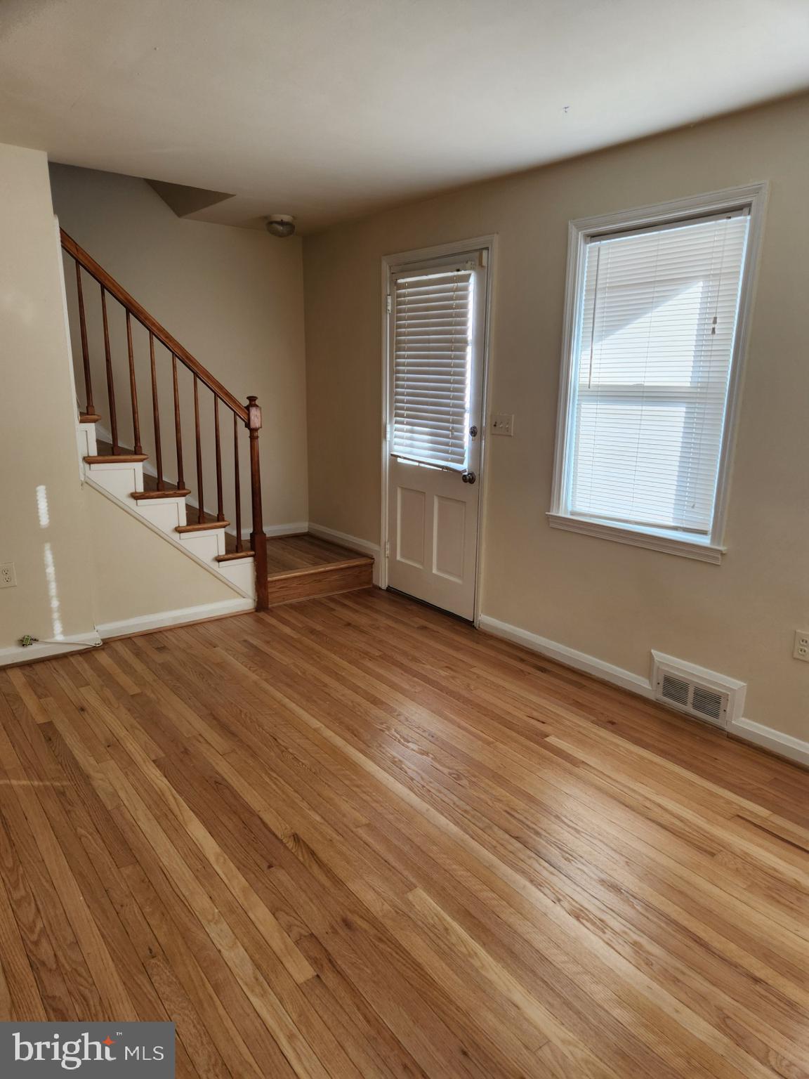 1330 Meridene Drive Baltimore, MD 21239 - Photo 3 of 15 a view of an empty room with wooden floor and a window