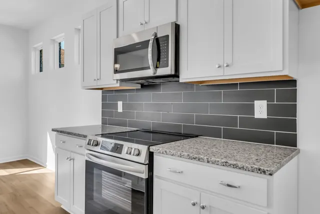 a view of kitchen with wooden floor and electronic appliances