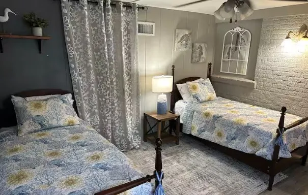 a bedroom with a bed lamp and wooden floor