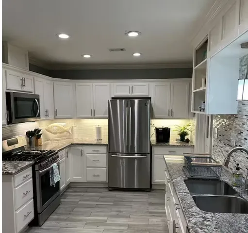 a kitchen with a sink stainless steel appliances and counter space