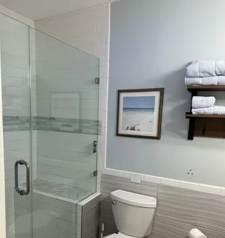 a bathroom with a toilet and a shower