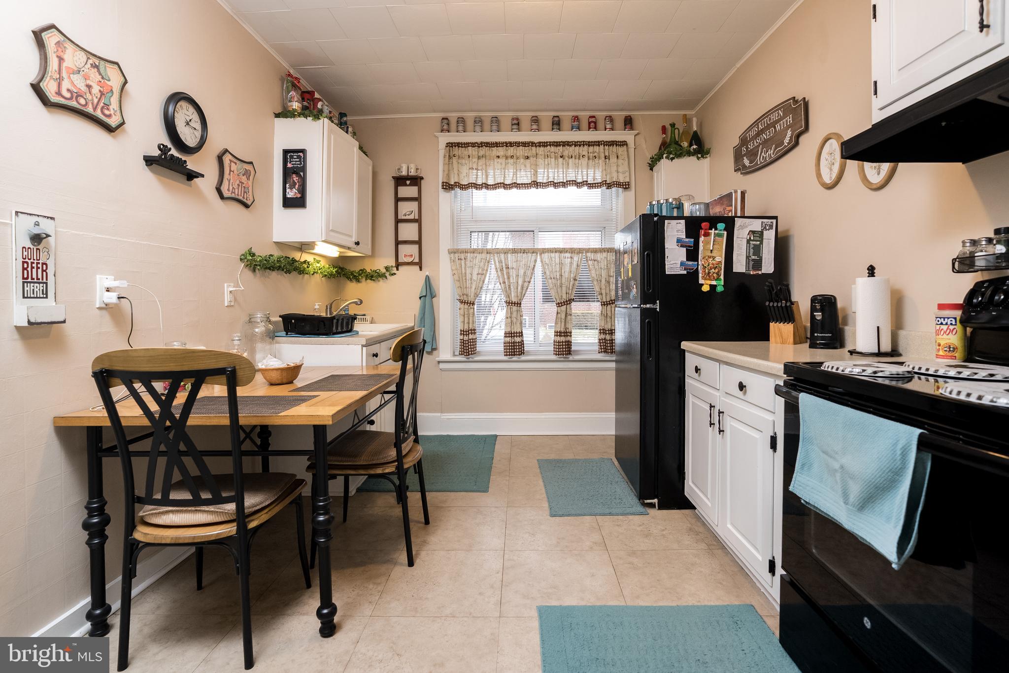 102 Ruby Street Lancaster, PA 17603 - Photo 8 of 41 a kitchen with stainless steel appliances a table chairs and a refrigerator