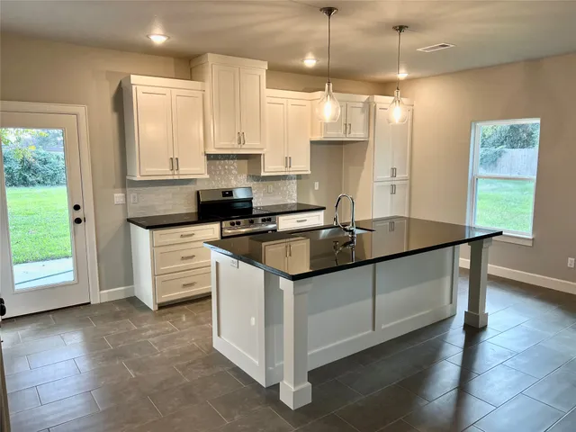 a kitchen that has a sink a window and stainless steel appliances